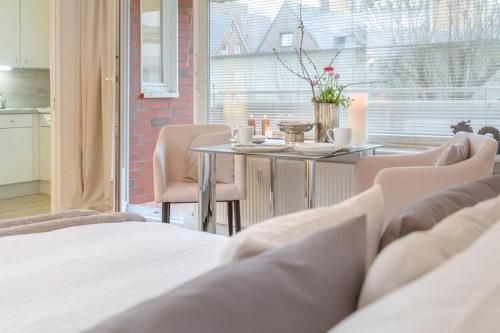 una camera da letto con tavolo, sedie, tavolo e finestra di Bommi7 a Westerland