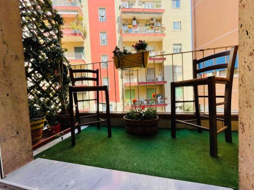 Un balcón con 2 sillas y un reloj. en Cutapp Guest House en Catania