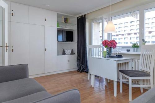 uma sala de estar com uma cozinha com uma mesa e uma secretária em Strandkoenig 4 _AD1 _ 206_ em Westerland