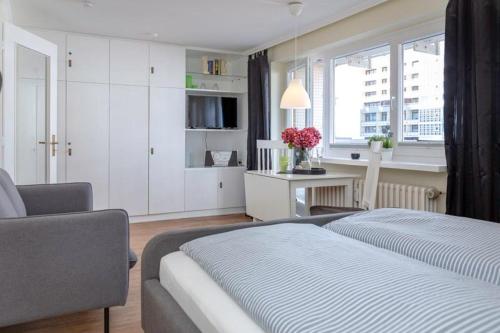 1 dormitorio con cama, escritorio y ventana en Strandkoenig 4 _AD1 _ 206_, en Westerland