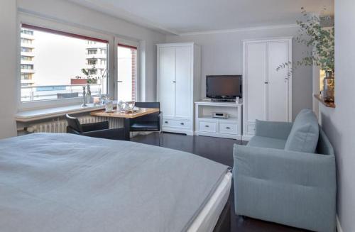 - une chambre avec un lit, une table et une télévision dans l'établissement Ad5 408 Dwarsloeper 3, à Westerland