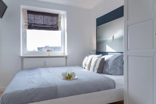 Un dormitorio blanco con una cama con un bol de fruta. en F23 26 Beachlife, en Westerland