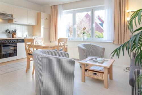uma cozinha e sala de estar com cadeiras e uma mesa em Haus Lia Links App 3 em Tinnum