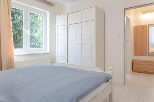 um quarto branco com uma cama grande e 2 janelas em Haus Lia Links App 3 em Tinnum