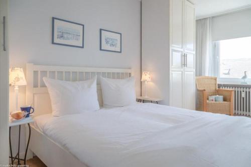 un grande letto bianco con cuscini bianchi in una camera da letto di Duen12_43 a Westerland