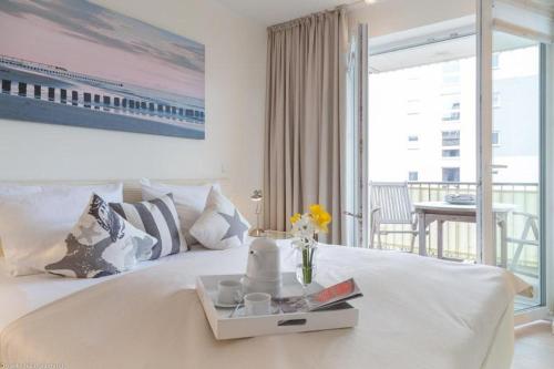 a bedroom with a large white bed and a balcony at Bra5B 5 Oceanfront in Westerland