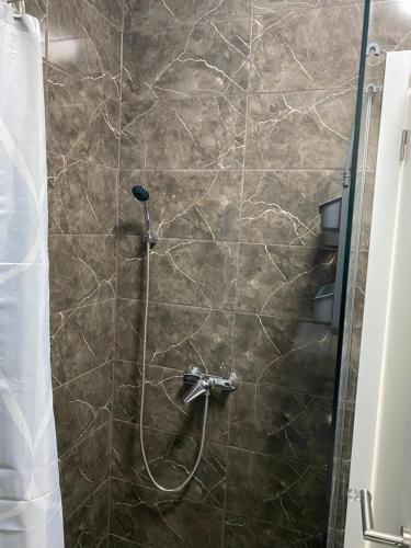 uma cabina de duche com uma cortina de chuveiro e um chuveiro em New Apartment in the City em Visoko