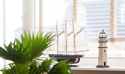un bateau à jouets et un phare sur un rebord de fenêtre dans l'établissement Duen12_27 Sea la Vie, à Westerland