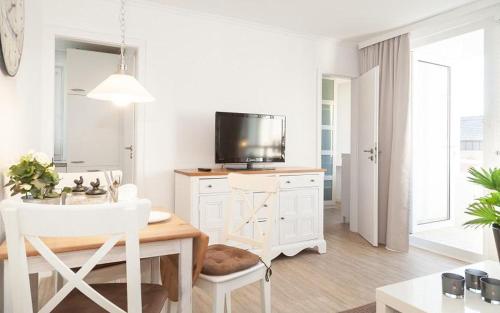 - un salon blanc avec une table et une télévision dans l'établissement Duen12_27 Sea la Vie, à Westerland
