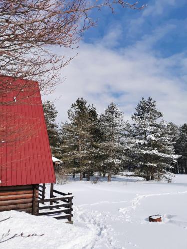 a barn with a red roof in the snow at Breeze Home Cottage in Cetinje