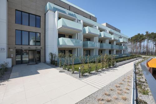 an apartment building with a courtyard with trees at Platinium Rewal Aparthotel 21,23 in Rewal