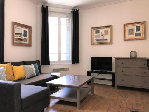 sala de estar con sofá y mesa de centro en Appartements Maisons Bleues, en Honfleur