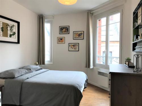 une chambre blanche avec un lit et une fenêtre dans l'établissement Appartements Maisons Bleues, à Honfleur