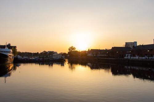 a sunset over a river with the sun setting at Copthorne Hotel Manchester Salford Quays in Manchester