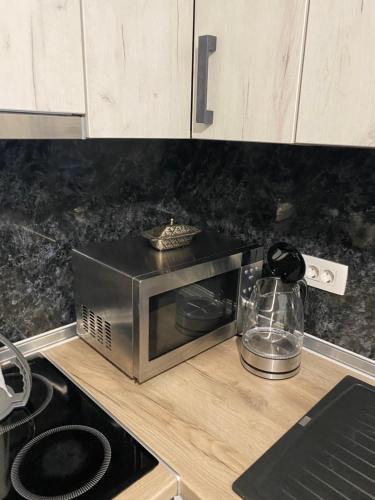 a microwave sitting on a counter in a kitchen at New Apartment in the City in Visoko