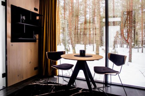 ÖÖD Hötels Laheranna SUDU- with sauna في Punakivi: طاولة وأربعة كراسي في غرفة مع نافذة