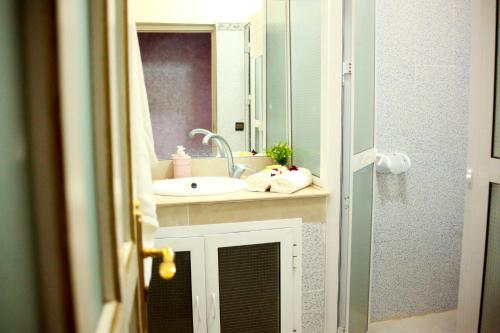 a bathroom with a sink and a mirror at Riad Nasma Souihla in Marrakech