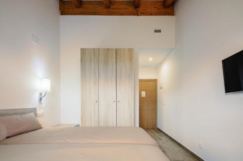 a bedroom with a bed and a tv on a wall at O Trancallo in Viana do Bolo