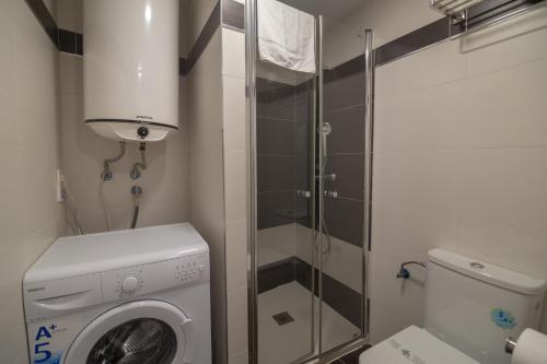 een kleine badkamer met een wasmachine en een douche bij Apartamentos Mayor by Be Alicante in Alicante