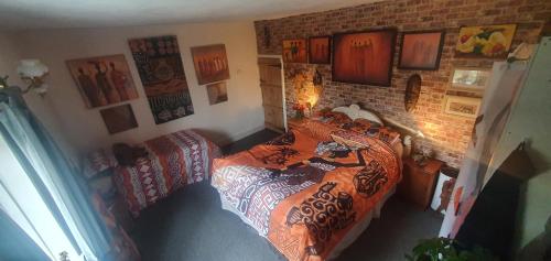 a bedroom with two beds and a brick wall at rosedale cottage in Walsgrave on Sowe