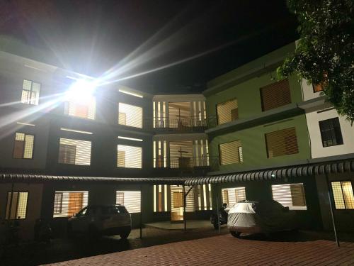 a building with the sun shining on it at night at Airavatham Apartments in Guruvāyūr