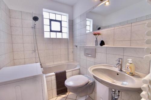 a white bathroom with a sink and a toilet at work & longstay apartment in Düsseldorf in Düsseldorf