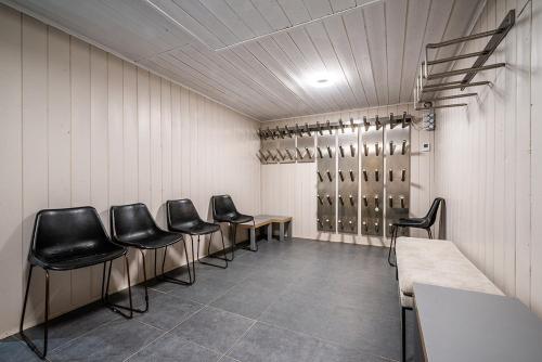 a waiting room with black chairs and wine racks at Eden Hotel, Apartments and Chalet Chamonix Les Praz in Chamonix-Mont-Blanc