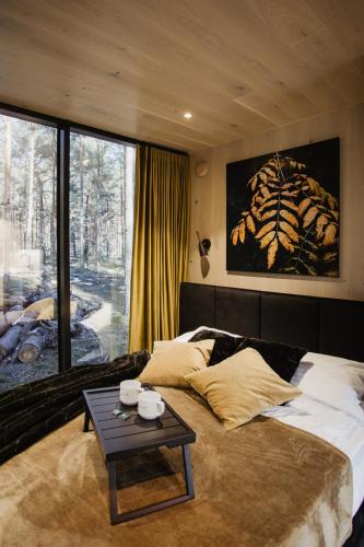 - une chambre avec un grand lit et une table dans l'établissement ÖÖD Hötels Laheranna SUDU- with sauna, à Punakivi