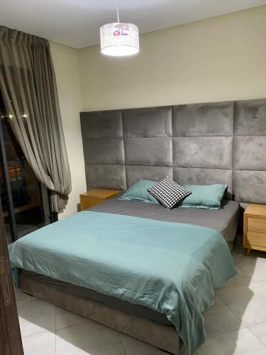 a bedroom with a large bed with a large headboard at Oceanica by Smir Park luxury apartment Marina Smir in M'diq