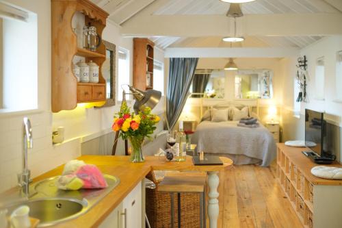 a kitchen with a sink and a bed in a room at Old Fire Station - quaint and quirky little home in Brandon