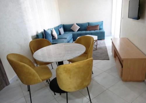 a living room with a table and chairs and a couch at Oceanica by Smir Park luxury apartment Marina Smir in M'diq