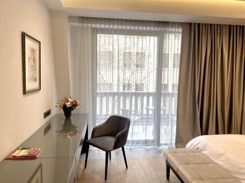 a hotel room with a bed and a desk and a window at Heart of Yerevan - City Center Luxury Apartments in Yerevan