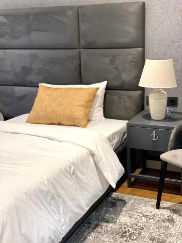 a bedroom with a large bed with a gray headboard at Heart of Yerevan - City Center Luxury Apartments in Yerevan