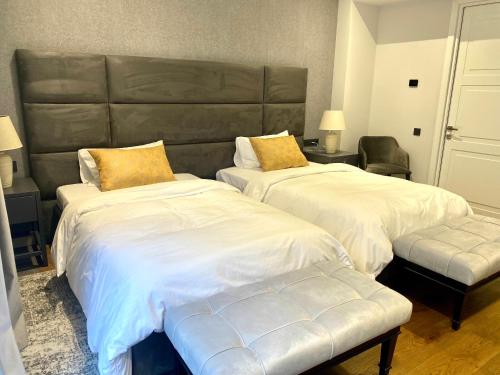 a bedroom with two beds and a large headboard at Heart of Yerevan - City Center Luxury Apartments in Yerevan