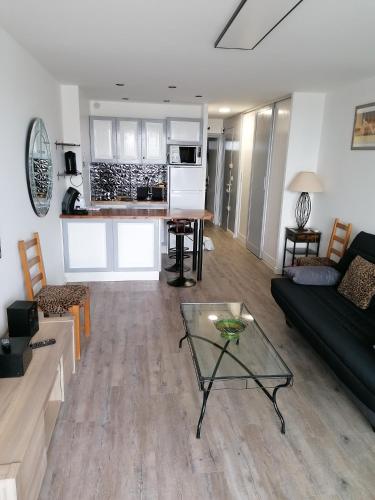 un salon avec un canapé et une table dans l'établissement Cap Agde Natu Port Ambonne, au Cap d'Agde