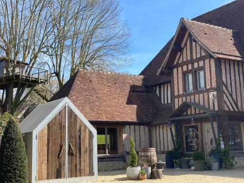 a house with a wooden door in front of it at Locations - Domaine Le Coq Enchanté in Cambremer
