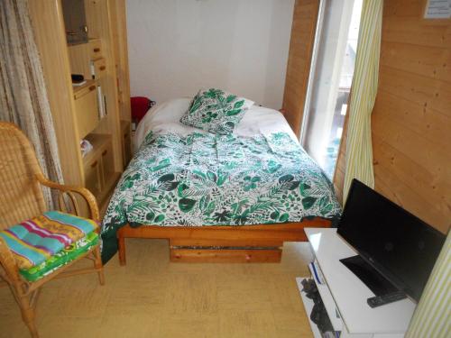 - une petite chambre avec un lit et un bureau avec un ordinateur dans l'établissement Studio confortable à Cauterets - 40 m² - Vue sur la montagne, à Cauterets