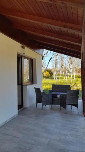 eine Terrasse mit 3 Stühlen und einem Tisch darauf in der Unterkunft Apartment Lena in Gornji Vaganac