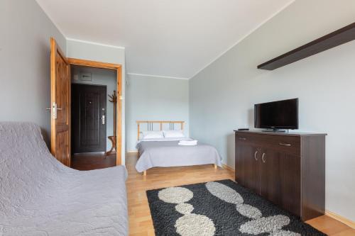 1 dormitorio con 1 cama y TV de pantalla plana en Sopot by the Beach, en Sopot