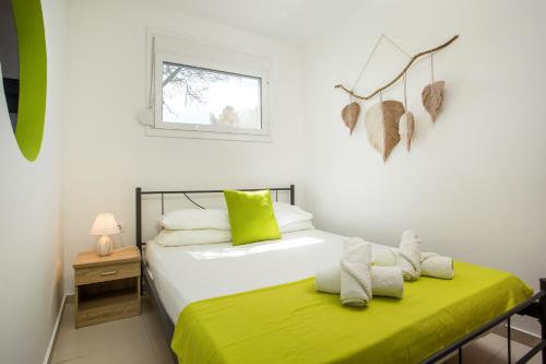 sypialnia z 2 łóżkami z zieloną pościelą i oknem w obiekcie GK Home I part of Gk Fitness Club w mieście Faliraki