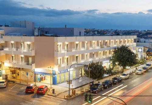 an apartment building on a city street at night at Asterion Hotel in Heraklio Town