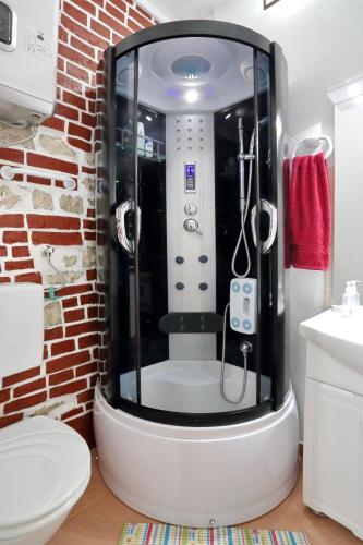 a bathroom with a shower in a brick wall at Apartment City Center Dragica in Zadar