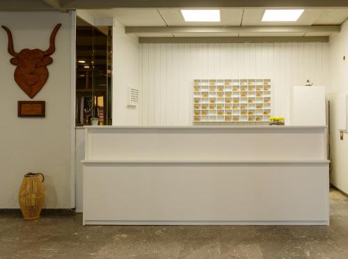 a white counter in a room with a bull head on the wall at Asterion Hotel in Heraklio Town