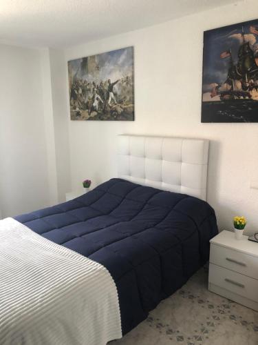 - une chambre avec un lit et une peinture murale dans l'établissement Apartamento de verano 1 habitación, à Ajo