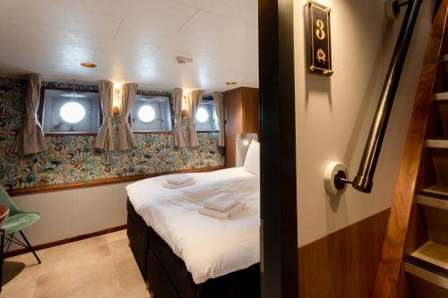 Ein Bett oder Betten in einem Zimmer der Unterkunft Hotelboot Koningin Emma I Kloeg Collection