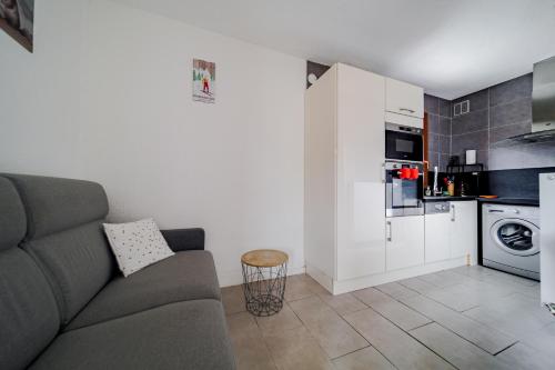 un salon avec un canapé et une cuisine dans l'établissement Max, aux Angles