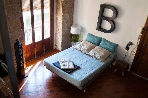 バレンシアにあるBUBUFLATS Mossénのベッドルーム1室(プレート付きのベッド1台付)
