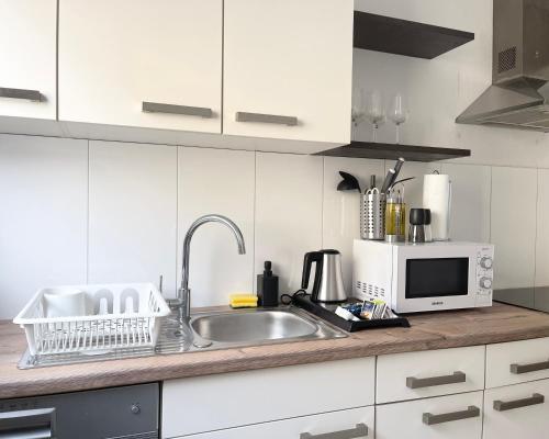 a kitchen counter with a sink and a microwave at Moderne Studios im Herzen von Osnabrueck in Osnabrück