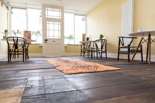 a room with a table and chairs and a rug at Severnside Press BnB in Newnham