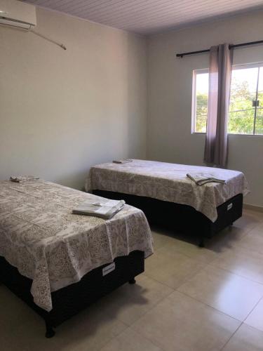 LajeadoにあるPousada Recanto Lajeadoの窓付きの客室で、ベッド2台が備わります。